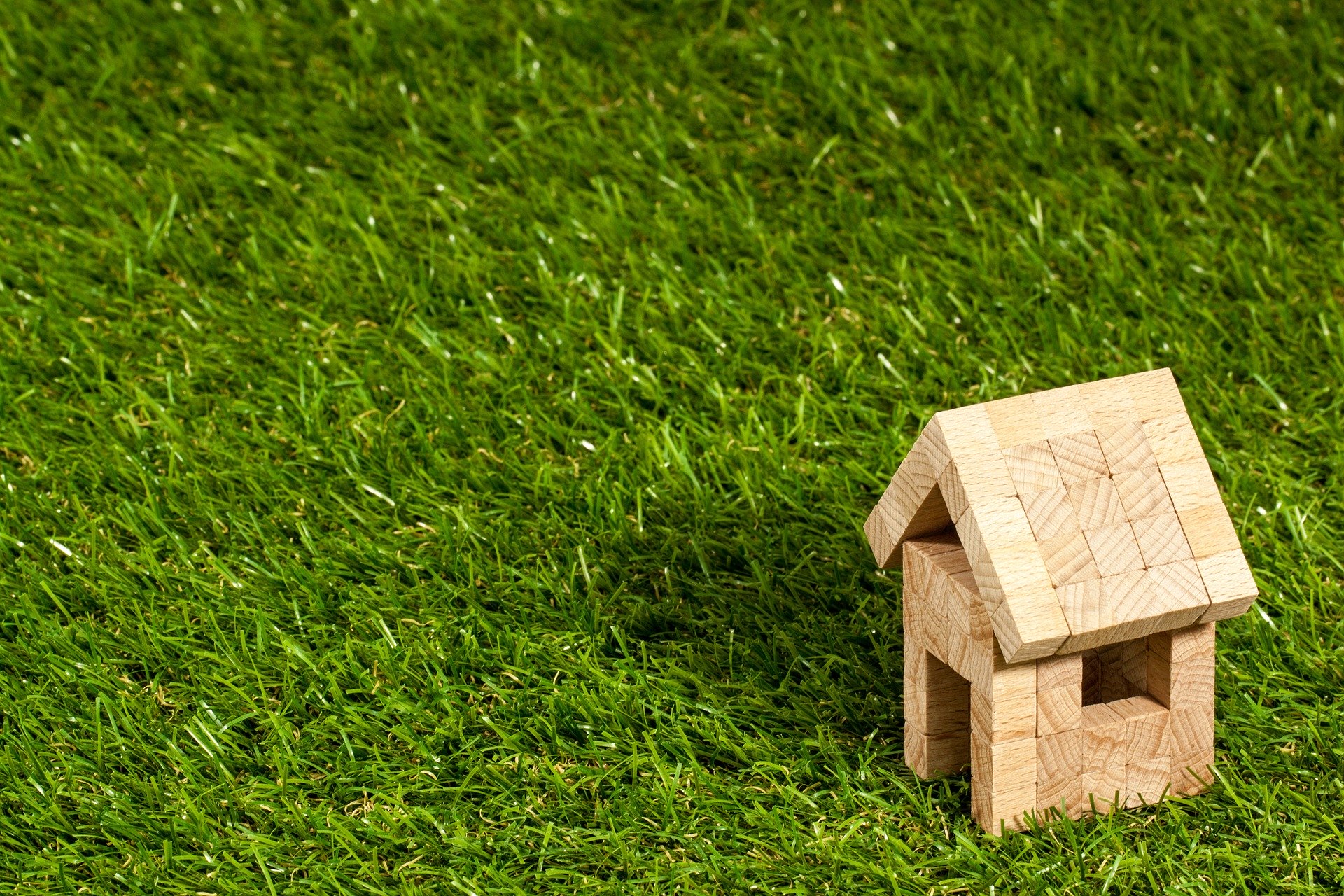 small house figurine on fake grass