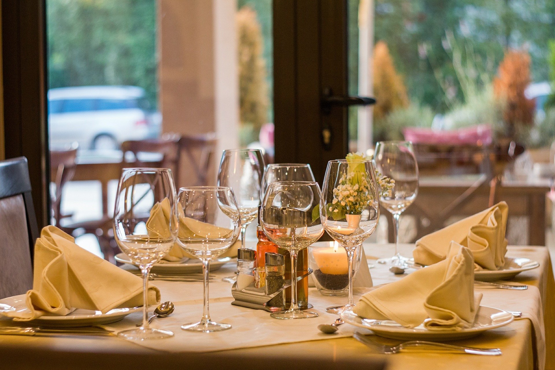 dinner table set with glasses, napkins, and plates