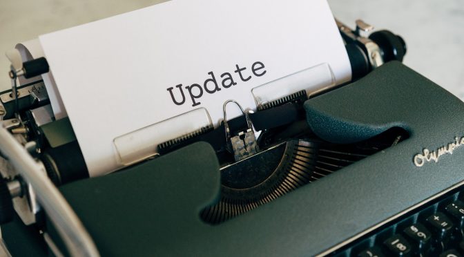 typewriter with paper showing the printed word "update"