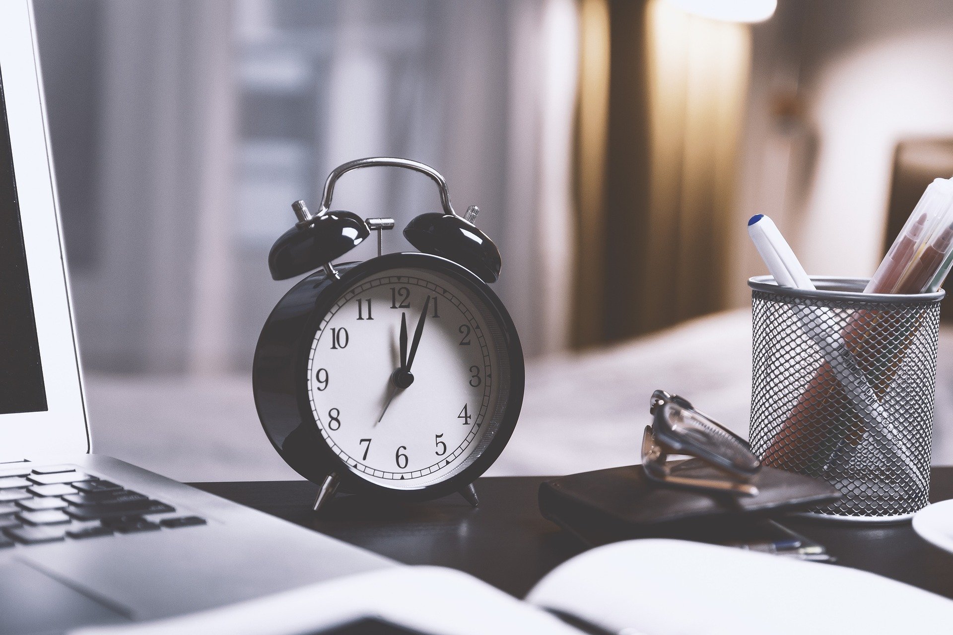 worker's desk with a close up of an alarm clock