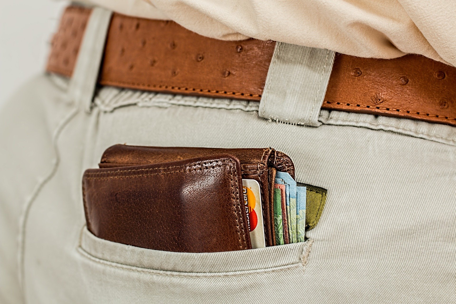 a full wallet peeping out of a clothing pocket