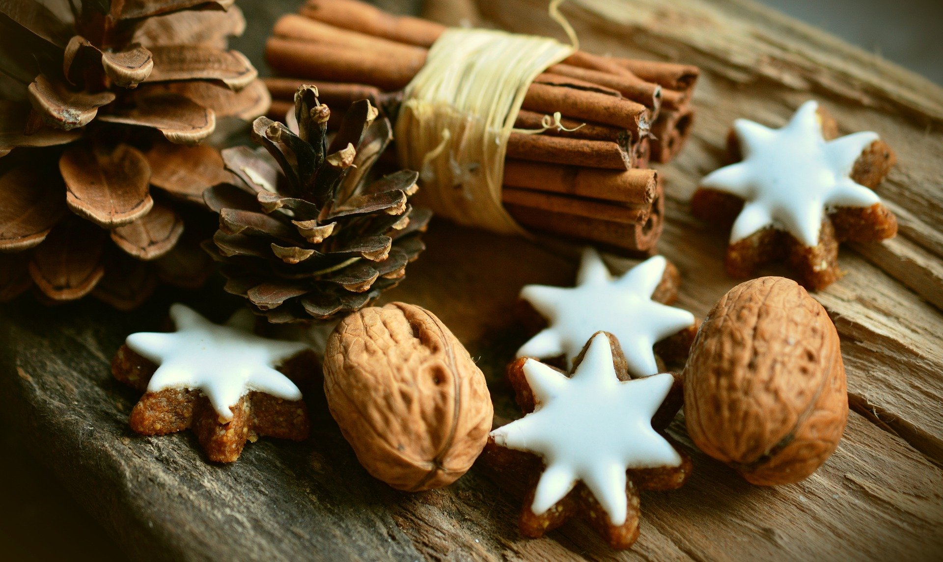 Christmas star shaped cookies next to cinnamon sticks and acorns