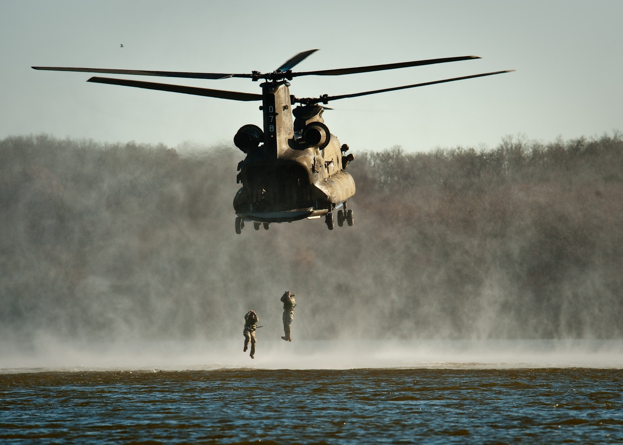 military team hanging from helicopter